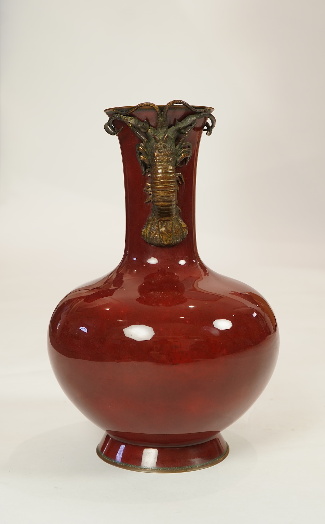 An unusual Japanese sang-de-boeuf ground cloisonné enamel and gilt metal mounted vase